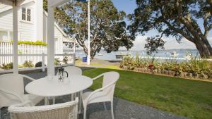 a patio with a table and chairs and a patio umbrella at Hananui Lodge and Apartments in Russell