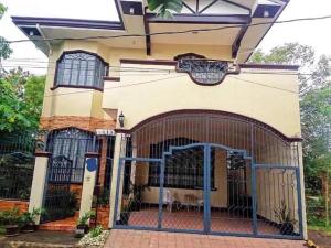 a house with a gate in front of it at Juliet Guest House near Enchanted Kingdom in Balibago