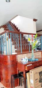 a table with a vase of flowers on top of a staircase at Juliet Guest House near Enchanted Kingdom in Balibago