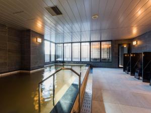 a pool of water in a building with windows at Hotel Sonia Otaru in Otaru