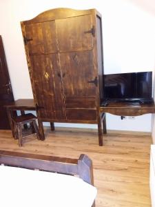 a wooden dresser and a desk with a tv at HANUL TENTEA in Săcel
