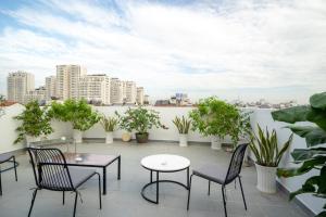 a patio with chairs and tables and potted plants at Park Hill Hotel - Phu My Hung in Ho Chi Minh City
