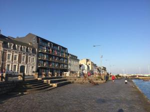 a group of buildings on a street next to the water at Loft de l'armateur in Fécamp