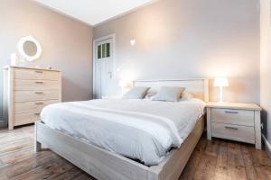 ブルージュにあるCharmant appartement met zicht Damse vaart @Bruggeの白いベッドルーム(大型ベッド1台、ドレッサー付)