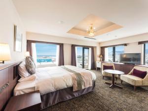 a hotel room with a bed and a desk and a television at Hotel Sonia Otaru in Otaru
