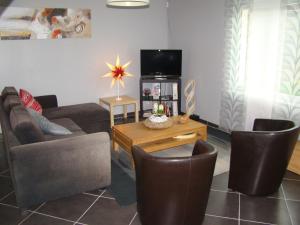 a living room with a couch and chairs and a tv at le gite d'olhain in Fresnicourt-le-Dolmen