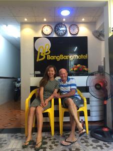 a man and a woman sitting in yellow chairs in a store at BangBang Motel in Can Tho