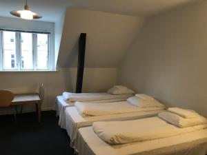 a hotel room with two beds and two lamps at Hotel Euroglobe in Copenhagen