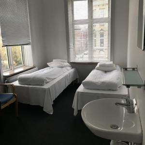 
a hotel room with two beds, a toilet and a window at Hotel Euroglobe in Copenhagen
