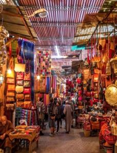 a market with people walking inside of a store at Chez Maya in Marrakech
