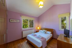 une chambre avec un grand lit et deux fenêtres dans l'établissement Larnaca Villa Anthea 12, à Larnaka 30 autres photos