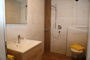 a bathroom with a sink and a shower and a toilet at Appartement Ilvy in Söll