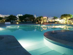Holiday Rooms Domina Coral Bay في شرم الشيخ: مسبح كبير بمياه زرقاء في الليل