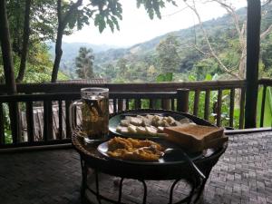 a table with a plate of food and a drink at Akha Hill House in Ban Doi Hang