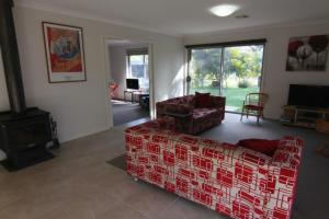 a living room with a red couch and a fireplace at 19 Georgian Court in Bright