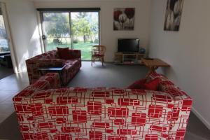 a living room with a couch and a tv at 19 Georgian Court in Bright +2 photos