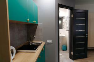 uma cozinha com armários verdes e um lavatório em Ivana Fedorova 30 em Lviv