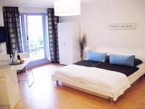 ein Schlafzimmer mit einem großen Bett mit blauen Kissen in der Unterkunft Apartment Cologne City in Köln