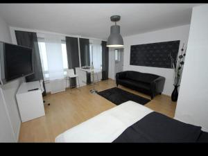 ein Schlafzimmer mit einem Bett, einem Sofa und einem TV in der Unterkunft Apartment Cologne City in Köln