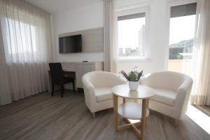 a living room with two chairs and a table at Hotel Europa in Marostica
