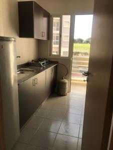a kitchen with white cabinets and a door to a window at Love House Tanger in Tangier +4 photos