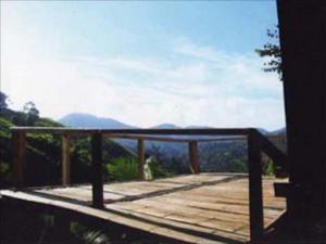 a wooden deck with a view of the mountains at Akha Hill House in Ban Doi Hang
