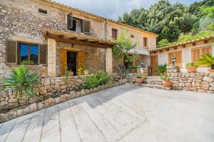 a house with a stone wall and a courtyard at Villa Can Pau By SunVillas Mallorca in Pollença