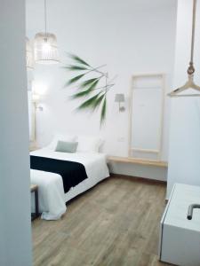 sypialnia z białym łóżkiem i palmą w obiekcie Sunny Stay Guest Houses w Alicante