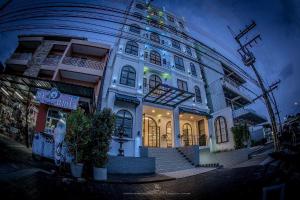 a large white building with stairs in front of it at The Seens Hotel in Krabi town
