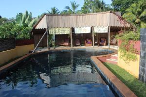 a swimming pool in front of a house at Hotel Ambalamanga in Nosy Be