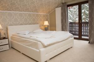 a white bed in a bedroom with a window at Platinvm B&B in Predeal