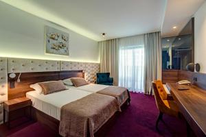 Hotel Scala d'Oro في فوديس: غرفة فندقية بها سرير كبير ومكتب