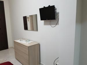 a bathroom with a sink and a tv on a wall at Sweet Home in Floridia