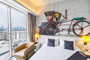 1 dormitorio con 1 cama y una bicicleta en la pared en Vivatel Kuala Lumpur, en Kuala Lumpur