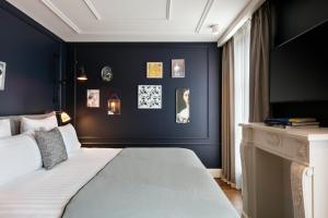 a bedroom with a bed and a blue wall at Royal Madeleine Hotel & Spa in Paris