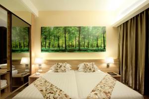 a bedroom with two beds and a painting on the wall at Vivatel Kuala Lumpur in Kuala Lumpur