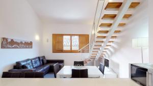 a living room with a couch and a staircase at Edificio Palomar - PalomarGroup in Valencia