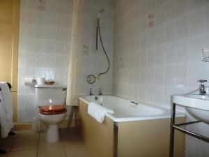 
a white bath tub sitting next to a white toilet at Duck's Inn in Aberlady
