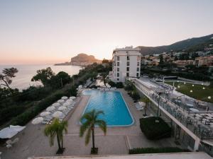 a view of a hotel with a swimming pool and the ocean at Hotel Santa Lucia Le Sabbie d'Oro in Cefalù