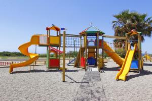 un parco giochi con scivolo sulla spiaggia di Appartamento fronte spiaggia a Marina di Pescoluse