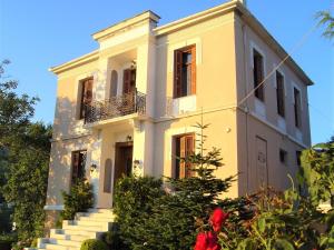 un edificio amarillo con escaleras delante en Vogiatzopoulou Guesthouse, en Agios Georgios Nilias