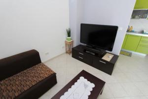 ein Wohnzimmer mit einem Sofa und einem Flachbild-TV in der Unterkunft Apartment Alen in Rovinj