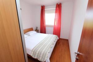 Schlafzimmer mit einem Bett und einem Fenster mit roten Vorhängen in der Unterkunft Apartment Alen in Rovinj