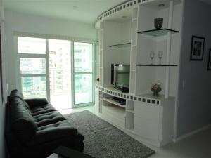 a living room with a couch and a tv at Barra da Tijuca Resort Bora Bora in Rio de Janeiro