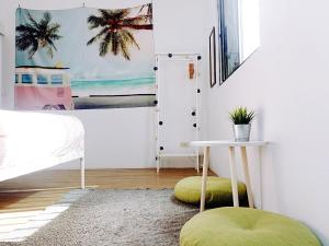 Un dormitorio con una cama y una mesa con un taburete verde en 都蘭朋友家 Dulan Friends Hostel, en Donghe