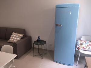 a blue refrigerator in a living room with a couch at 2 rue Palmaro à côté de la plage in Menton