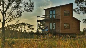 a house with a balcony on the side of it at Bien de Bien in Punta Del Diablo