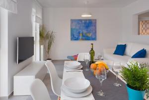 - un salon doté d'une table avec des assiettes et des verres à vin dans l'établissement ArtApArt D, à Rabac