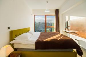 a bedroom with a large bed with a large window at Timber view apartment Silver Mountain Poiana Brasov in Poiana Brasov +29 photos