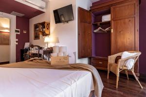 サン・ヴィート・ロ・カーポにあるHotel Pochoの紫の壁のベッドルーム1室、ベッド1台、椅子1脚が備わります。